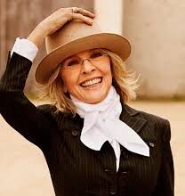 Diane Keaton smiling in her signature wide-brimmed hat and tailored suit, representing her timeless Hollywood style.